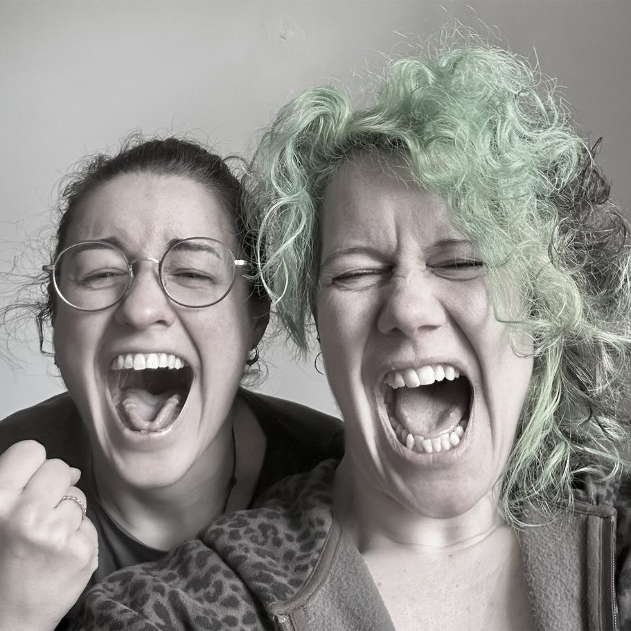Zwei Gesangslehrerinnen singen mit weit geöffnetem Mund und viel Freude – Gesangsunterricht, Gesangscoaching und Workshops.